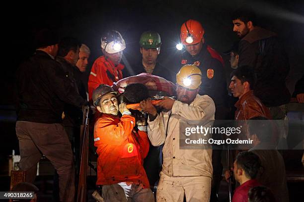 Miners are helped by rescue workers and friends from the coal mine on May 14, 2014 in Soma, Manisa, Turkey. An explosion and fire in the coal mine...