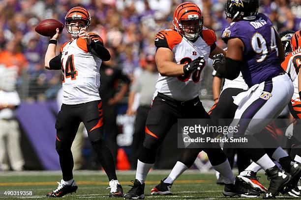 Quarterback Andy Dalton of the Cincinnati Bengals drops back to throw while guard Kevin Zeitler of the Cincinnati Bengals works against defensive...
