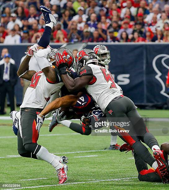 Jonathan Grimes of the Houston Texans is double teamed by D.J. Swearinger of the Tampa Bay Buccaneers and Lavonte David in the first quarter at NRG...