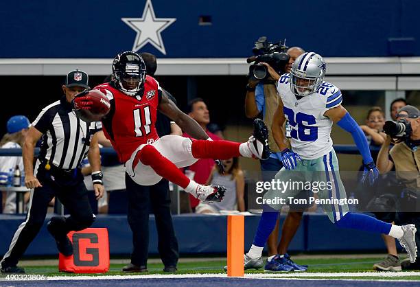Julio Jones of the Atlanta Falcons leaps over the goal line to score a touchdown as Tyler Patmon of the Dallas Cowboys looks on the in the third...