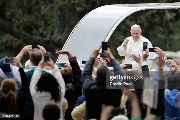 Pope Francis acknowledges faithful as he parades on his way to celebrate Sunday Mass at Benjamin Franklin Parkway September 27, 2015 in Philadelphia,...