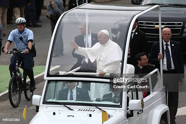 Pope Francis waves as he drives along Benjamin Franklin Parkway to lead Mass on September 27, 2015 in Philadelphia, Pennsylvania. Pope Francis is on...