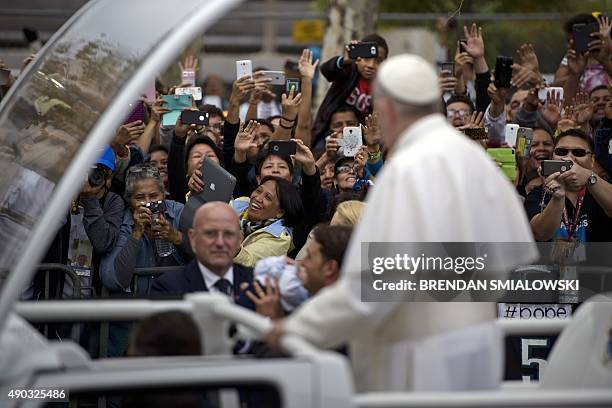 The crowd reacts as Pope Francis passes while traveling to a Mass for the World Meeting of Families on Benjamin Franklin Parkway September 27, 2015...