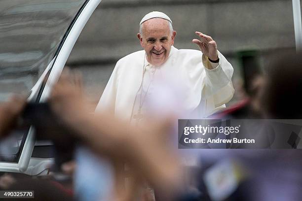 Pope Francis waves to the crowd from his popemobile while on his way to lead Mass at Benjamin Franklin Parkway on September 27, 2015 in Philadelphia,...