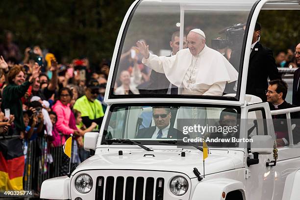 Pope Francis waves to the crowd from his popemobile while on his way to lead Mass at Benjamin Franklin Parkway on September 27, 2015 in Philadelphia,...