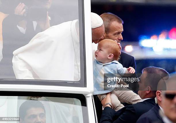 Pope Francis blesses a baby in the Popemobile during a parade September 27, 2015 in Philadelphia, Pennsylvania. Pope Francis is in Philadelphia for...