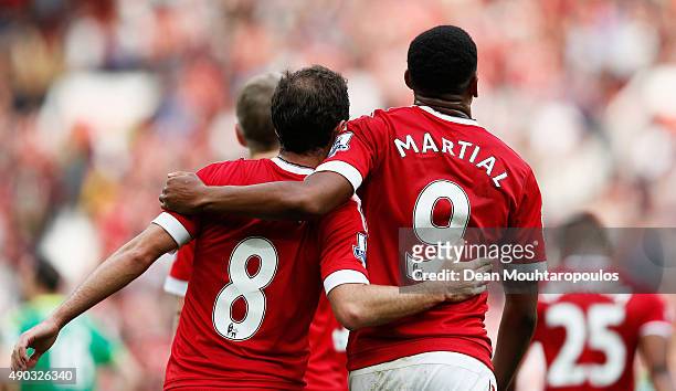 Juan Mata of Manchester United celebrates scoring his team's third goal with his team mate Anthony Martial during the Barclays Premier League match...