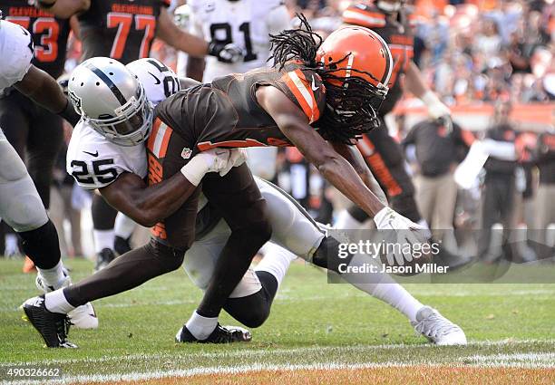 Travis Benjamin of the Cleveland Browns dives for a touchdown while being tackled by D.J. Hayden of the Oakland Raiders during the fourth quarter at...
