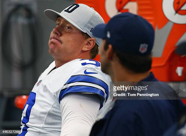 Brandon Weeden of the Dallas Cowboys sits on the bench with Tony Romo of the Dallas Cowboys in the final second of the fourth quarter against the...