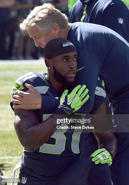 Head coach Pete Carroll of the Seattle Seahawks gives a quick hug to strong safety Kam Chancellor of the Seattle Seahawks before the game against the...