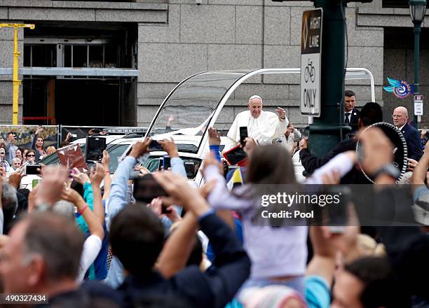 Pope Francis waves to the crowd from the Popemobile during a parade September 27, 2015 in Philadelphia, Pennsylvania. Pope Francis is in Philadelphia...