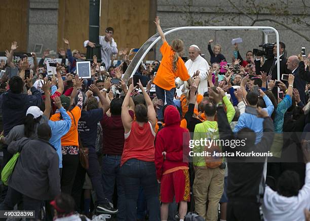 Pope Francis rides to mass in the Popemobile along Benjamin Franklin Parkway on September 27, 2015 in Philadelphia. This is the Pope's final day of a...