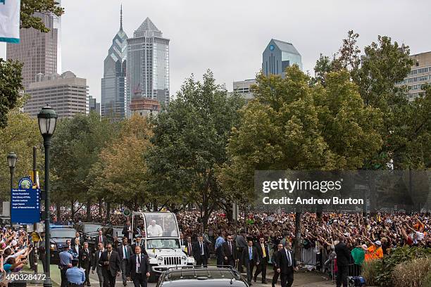 Pope Francis waves to the crowd from his popemobile while on his way to lead Mass at Benjamin Franklin Parkway on September 27, 2015 in Philadelphia,...