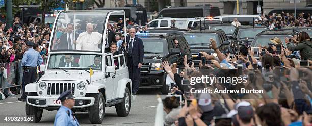 Pope Francis waves to the crowd from his popemobile while on his way to lead Mass at Benjamin Franklin Parkway on September 27, 2015 in Philadelphia,...