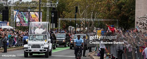 Pope Francis waves to the crowd from his popemobile while on his way to lead Mass at Benjamin Franklin Parkway on September 27, 2015 in Philadelphia,...