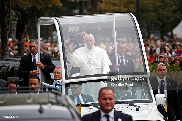 Pope Francis waves to the crowd from the Popemobile during a parade September 27, 2015 in Philadelphia, Pennsylvania. Pope Francis is in Philadelphia...