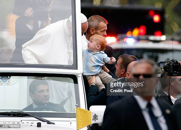 Pope Francis waves to the crowd from the Popemobile during a parade September 27, 2015 in Philadelphia, Pennsylvania. Pope Francis is in Philadelphia...