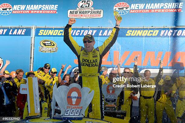 Matt Kenseth, driver of the Dollar General Toyota, celebrates in Victory Lane after winning the NASCAR Sprint Cup Series SYLVANIA 300 at New...