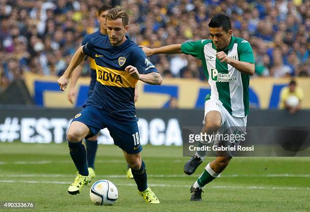 Nicolas Colazo of Boca Juniors struggles for the ball with Walter Erviti of Banfield during a match between Boca Juniors and Banfield as part of 26th...