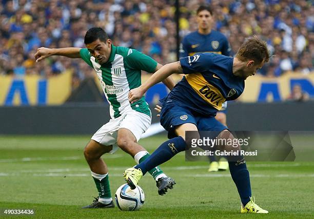 Nicolas Colazo of Boca Juniors battles for the ball with Walter Erviti of Banfield during a match between Boca Juniors and Banfield as part of 26th...