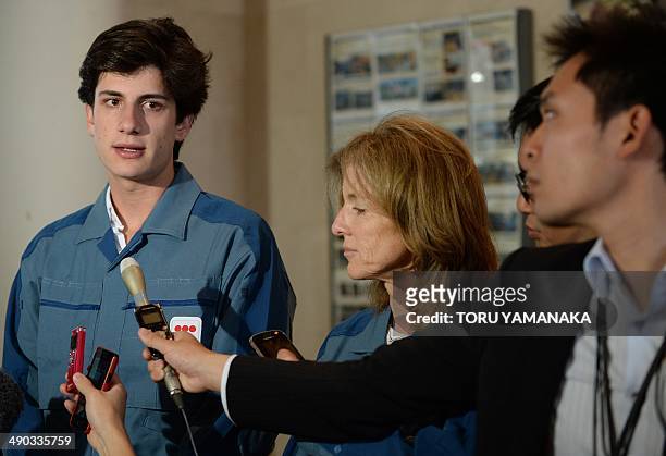 Wearing a uniform of Japan's Tokyo Electric Power Co. , Jack Kennedy Schlossberg speaks to journalists beside his mother US Ambassador to Japan...