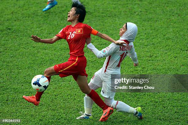 Le Thi Thuong of Vietnam is tackled by Shahnaz Yaseen of Jordan during the AFC Women's Asian Cup Group A match between Vietnam and Jordan at Thong...