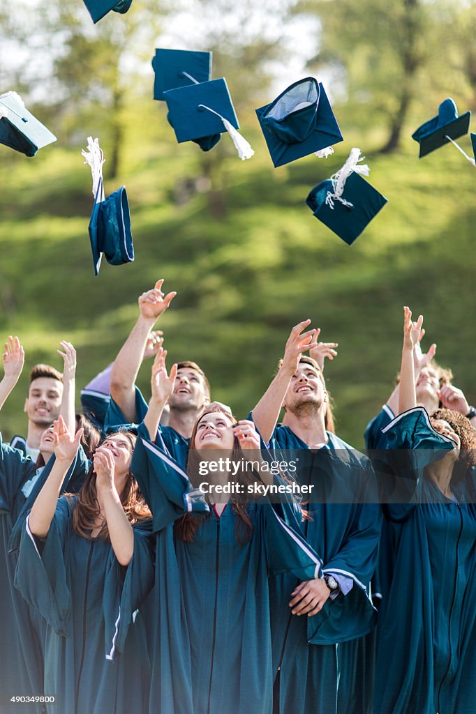 Glücklich Studenten Doktorhut werfen Graduierung Hüte in die Luft.