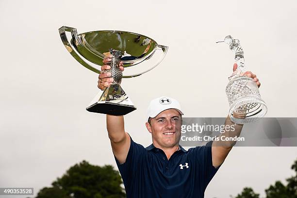 Jordan Spieth raises the tournament trophy and FedExCup trophy following his four stroke victory in the final round of the TOUR Championship by...