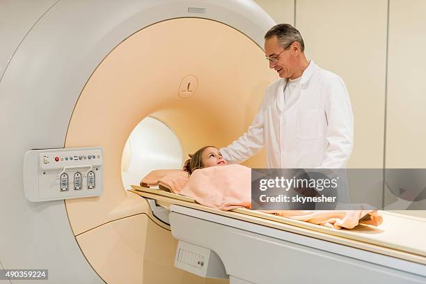 smiling radiologist talking to little girl before mri scan. - mri scan medische scan stockfoto's en -beelden