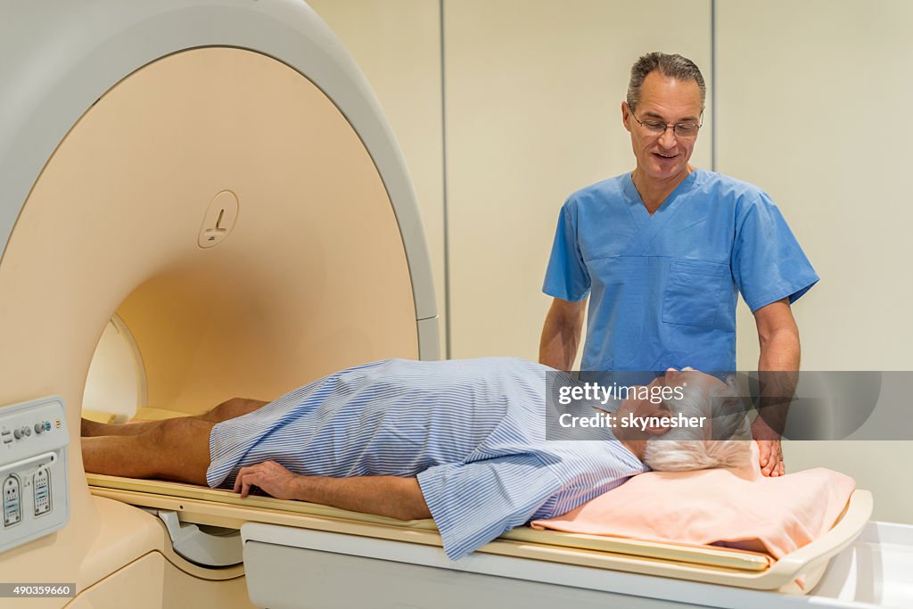 Radiologe Gespräch mit senior Patienten im Magnetresonanztomographie.