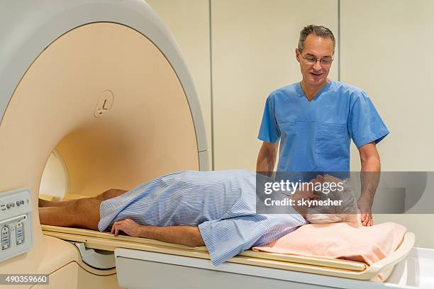 radiologist talking to  a senior patient at mri scan. - prostate cancer stockfoto's en -beelden