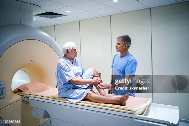 travailleur médical parlant à un patient senior à l'image à résonance magnétique. - tomographie par émission de positrons photos et images de collection