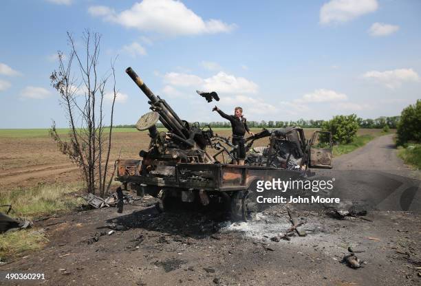 Local residents scavenge parts from a burnt Ukrainian military vehicle on May 14, 2014 in Dmytrivka, near Kramatorsk, Ukraine. Pro-Russian militants...