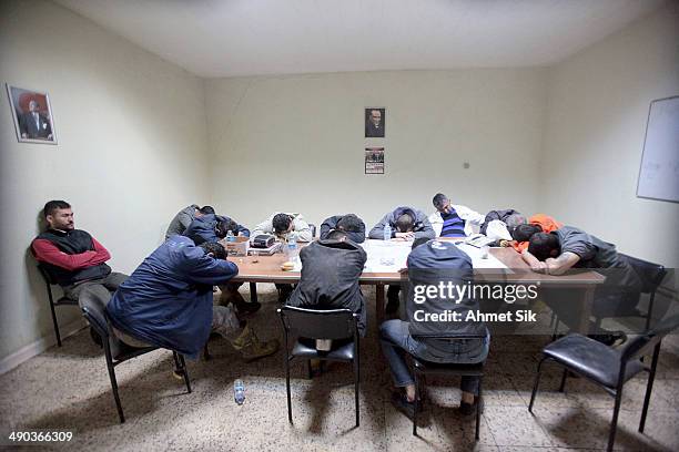 Exhausted miners rest as they await their trapped friends on May 14, 2014 in Soma, Turkey. Rescuers pulled more dead and injured from the coal mine...