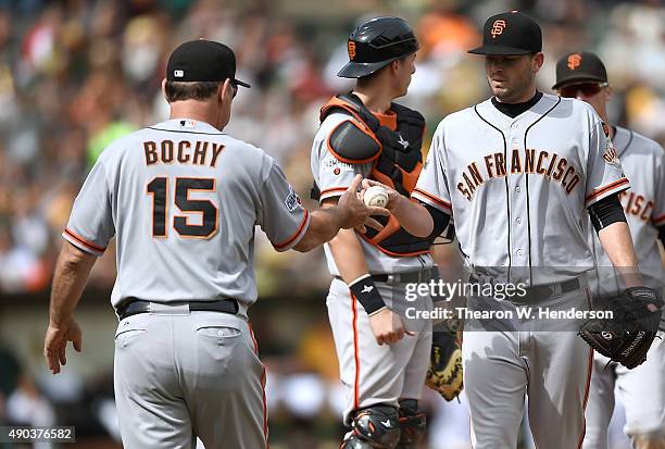 Manager Bruce Bochy of the San Francisco Giants take the ball from pitcher Chris Heston taking him out of the game against the Oakland Athletics in...