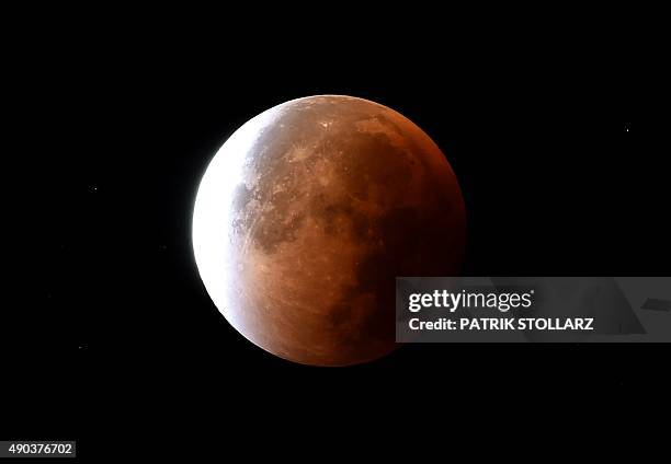 The return from a total lunar eclipse to a moon is seen in the dark sky in Essen, western Germany, on September 28, 2015. AFP PHOTO / PATRIK STOLLARZ