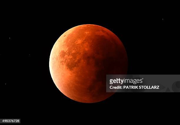 The return from a total lunar eclipse to a moon is seen in the dark sky in Essen, western Germany, on September 28, 2015. AFP PHOTO / PATRIK STOLLARZ