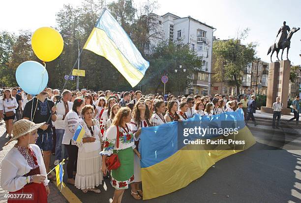 Ukrainians dressed in vyshyvankas with traditional embroideries carry Ukrainian flag during the March in vyshyvankas. Vyshyvanka is the Slavic...