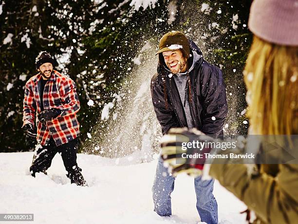 laughing group of friends having snowball fight - fight for life stock pictures, royalty-free photos & images