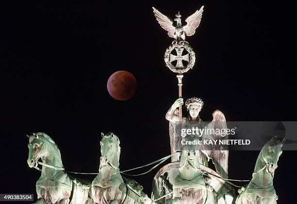 So-called "blood moon" can be seen behind the Quadriga sculpture on top of Berlin's landmark the Brandenburg Gate during a total lunar eclipse on...