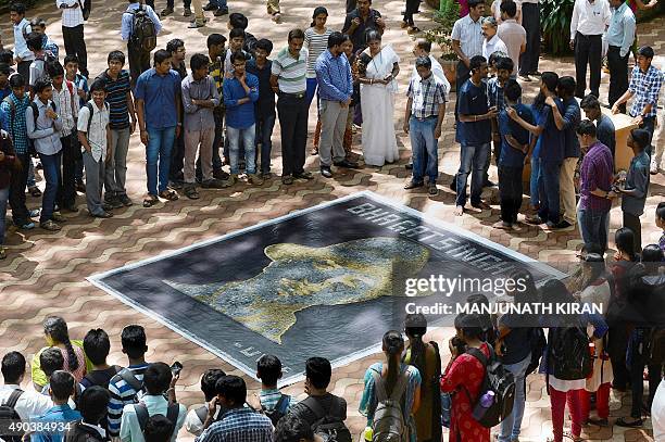 Students and staff of the University Visvesvaraya College of Engineering look at a portrait of Indian independence fighter Bhagat Singh, made by the...