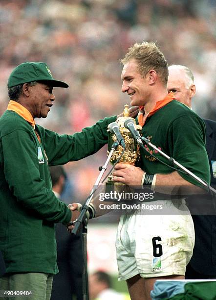 Captain Francois Pienaar of South Africa receives the William Webb Ellis Cup from the South African President, Nelson Mandela after the Rugby World...