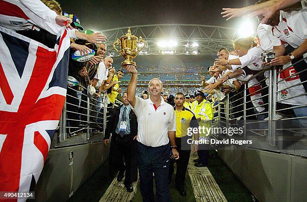The victorious Clive Woodward, head coach of England holds aloft the Webb Ellis cup as he leaves the field after England's victory in the Rugby World...