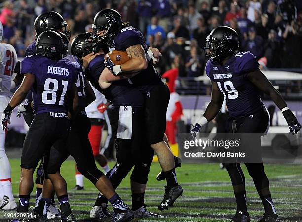 Dan Vitale fullback of the Northwestern Wildcats is greeted by his teammates after a touchdown against the Ball State Cardinals during the first half...