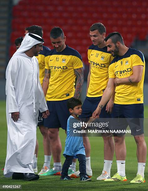 French Player Samir Nasri of Manchester City shakes hands with the son of Sheikh Mohammed bin Mansur bin Zayed, as his father looks on, at the Sheikh...