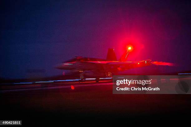 Pilots in a F/A-18E Super Hornet complete a night time, touch-and-go landing during Field Carrier Landing Practice for the Carrier Air Wing 5 of U.S....