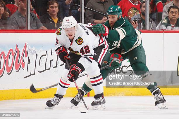 Joakim Nordstrom of the Chicago Blackhawks handles the puck with Clayton Stoner of the Minnesota Wild defending during Game Four of the Second Round...