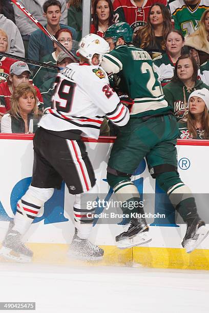 Bryan Bickell of the Chicago Blackhawks checks Nino Niederreiter of the Minnesota Wild during Game Four of the Second Round of the 2014 Stanley Cup...