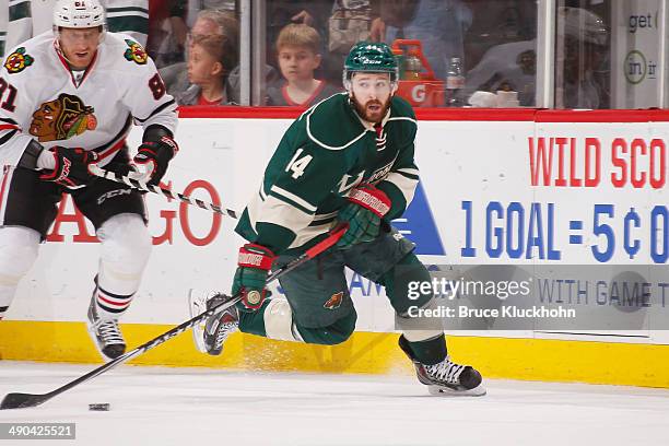 Justin Fontaine of the Minnesota Wild skates with the puck against the Chicago Blackhawks during Game Four of the Second Round of the 2014 Stanley...