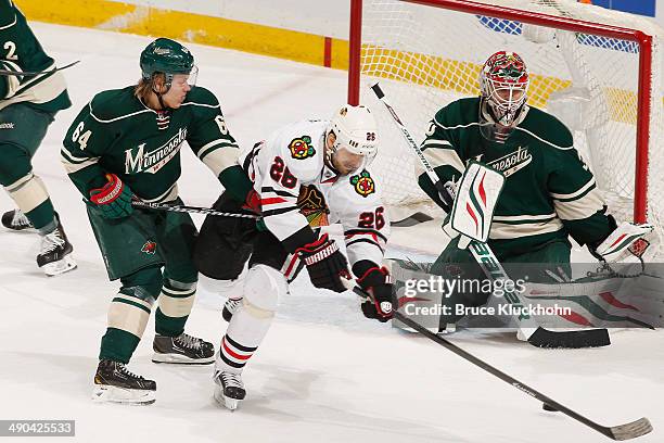 Michal Handzus of the Chicago Blackhawks scores a goal with Mikael Granlund and goalie Ilya Bryzgalov of the Minnesota Wild defending during Game...